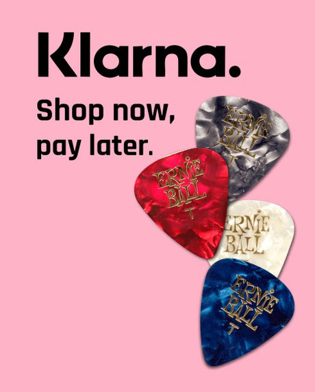 Guitar picks with 'Ernie Ball' branding on a pink background, featuring Klarna promotional text.