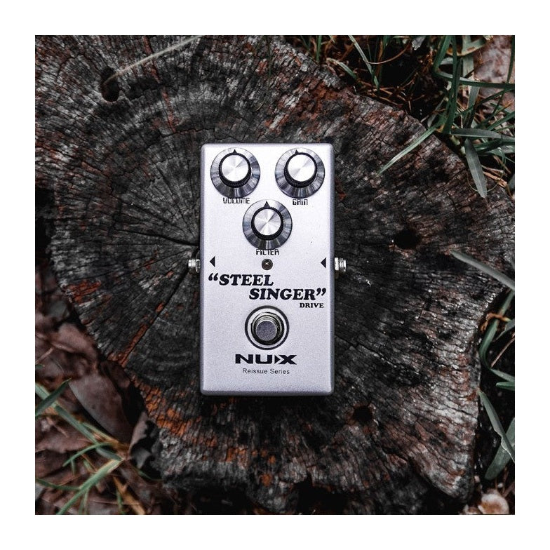 NUX Steel Singer Drive Pedal Zoomed Out Tree Trunk Lifestyle Shot